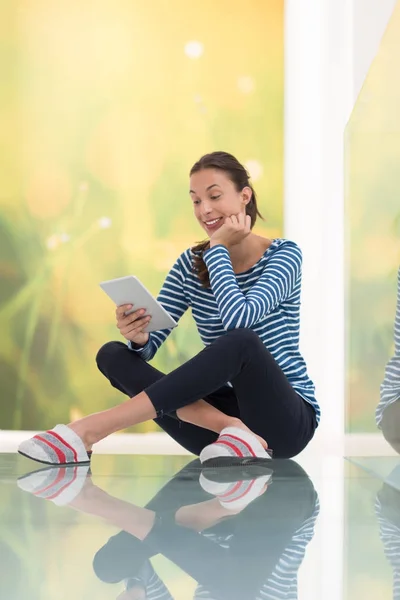 Young woman using tablet computer on the floor — Stock Photo, Image