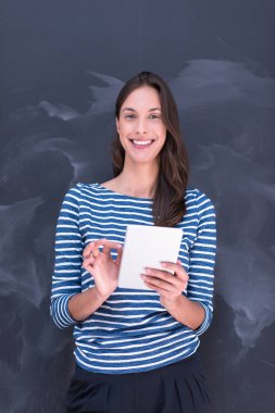 Tebeşir çizim kurulu önünde tablet kullanan kadın