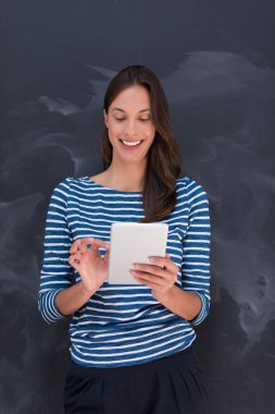 Tebeşir çizim kurulu önünde tablet kullanan kadın