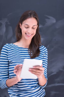 Tebeşir çizim kurulu önünde tablet kullanan kadın