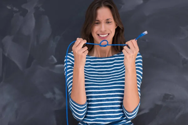 Mujer sosteniendo un cable de Internet delante de la pizarra de dibujo — Foto de Stock