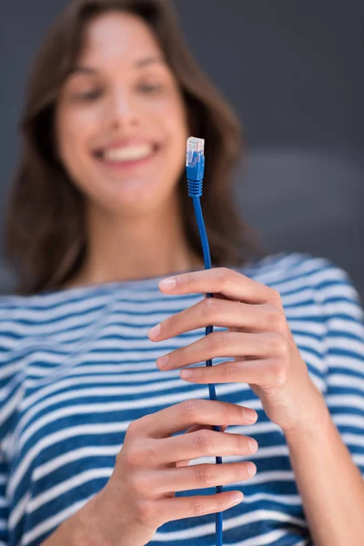 Frau hält Internetkabel vor Kreidezeichenwand — Stockfoto