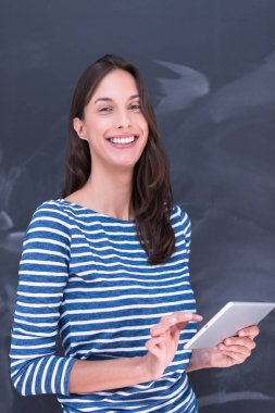 Tebeşir çizim kurulu önünde tablet kullanan kadın