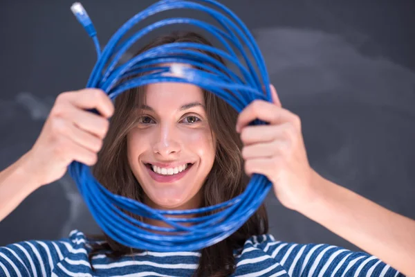 Mujer sosteniendo un cable de Internet delante de la pizarra de dibujo — Foto de Stock