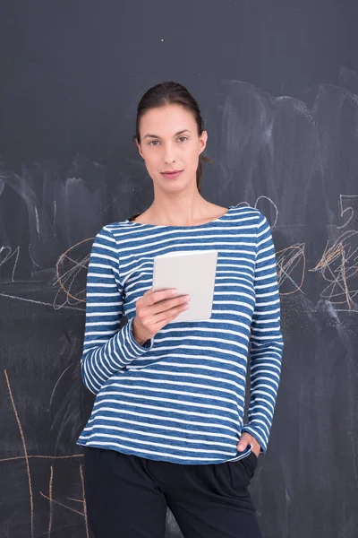 Woman using tablet  in front of chalk drawing board — Stock Photo, Image