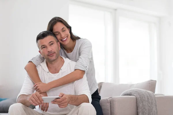 Glada par som använder mobiltelefon hemma — Stockfoto