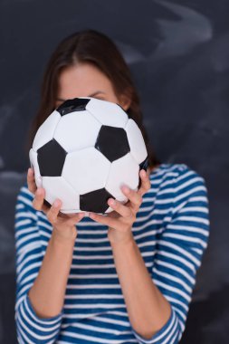 bir futbol topu tebeşir çizim kurulu önünde tutan kadın