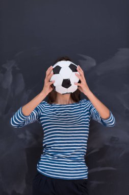 bir futbol topu tebeşir çizim kurulu önünde tutan kadın
