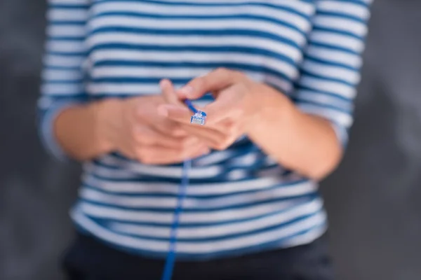 Mujer sosteniendo un cable de Internet delante de la pizarra de dibujo —  Fotos de Stock