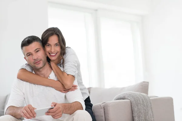 Casal feliz usando telefone celular em casa — Fotografia de Stock