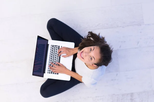Γυναίκα που χρησιμοποιούν φορητό υπολογιστή σχετικά με την κάτοψη ορόφου — Φωτογραφία Αρχείου