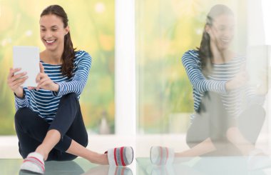 tablet bilgisayar yere kullanan genç kadın