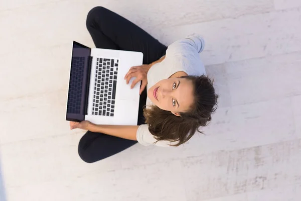 Donna che utilizza computer portatile sul pavimento vista dall'alto — Foto Stock