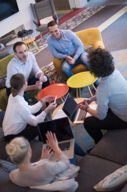 Bir grup genç iş adamı modern ofis binasında iş planlarını tartışıyor