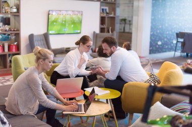 Bir grup genç iş adamı modern ofis binasında iş planlarını tartışıyor