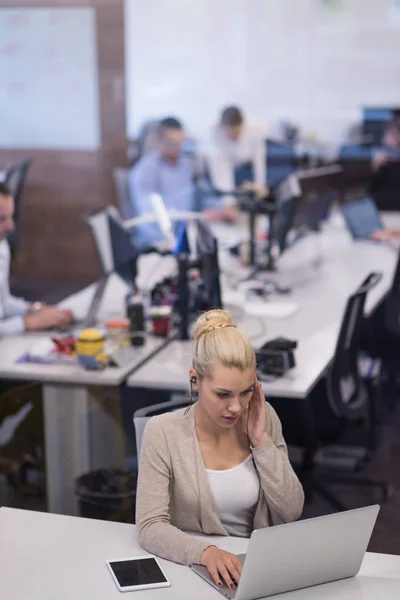 Business woman using a laptop in startup office — стоковое фото