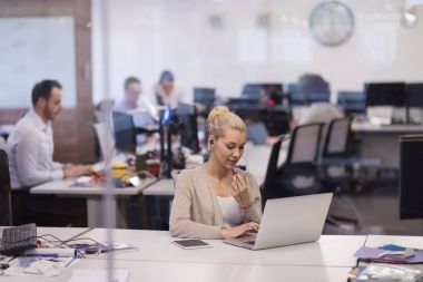 başlangıç ofisinde bir dizüstü bilgisayar kullanarak iş kadını