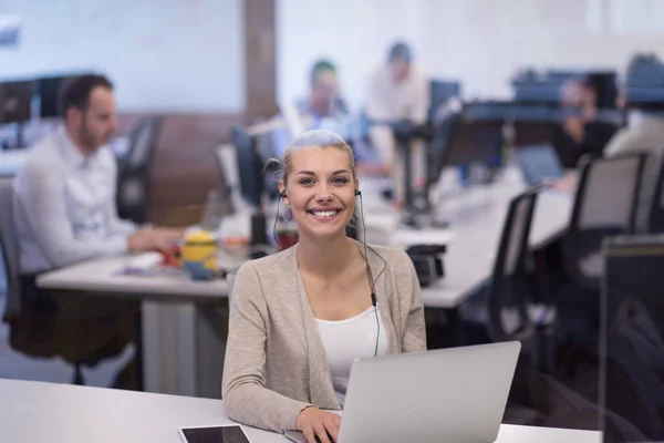 Businesswoman using a laptop in startup office — Stock Photo, Image