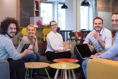 Bir grup genç iş adamı modern ofis binasında iş planlarını tartışıyor