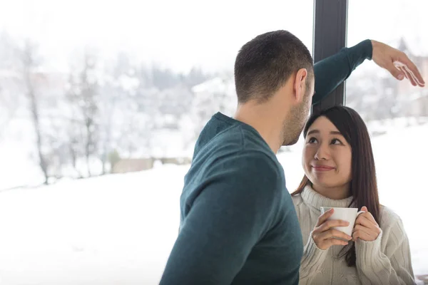 Multietniskt par njuta av morgonkaffe genom fönstret — Stockfoto