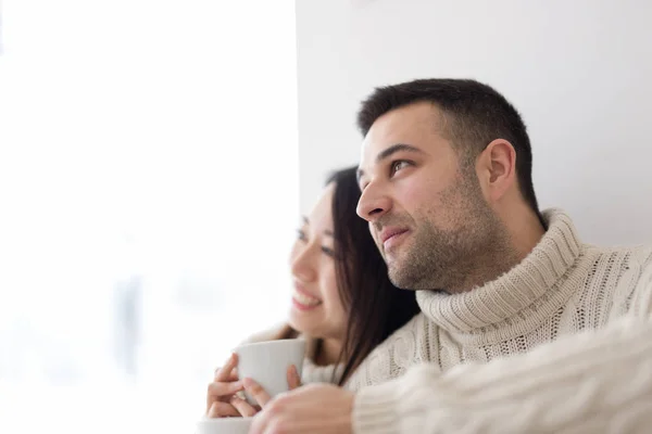 Coppia multietnica godendo caffè mattutino dalla finestra — Foto Stock