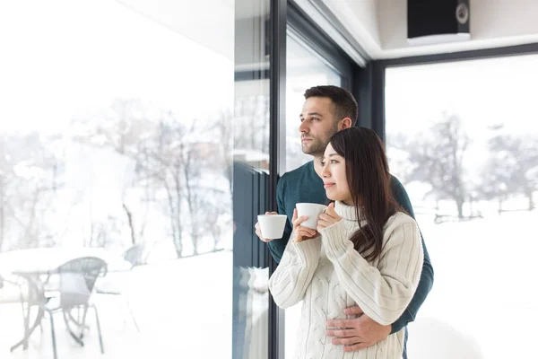 Multietniskt par njuta av morgonkaffe genom fönstret — Stockfoto
