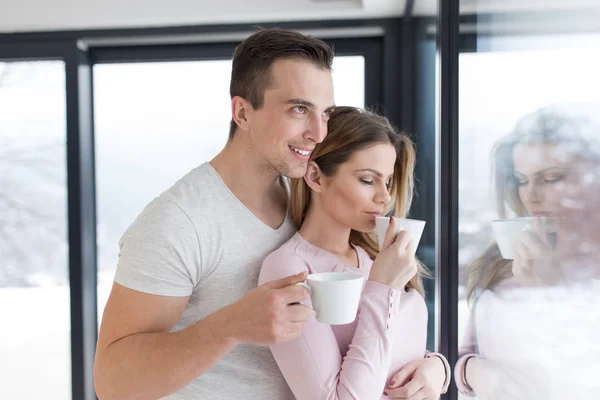 Young couple enjoying morning coffee by the window — Stock Photo, Image