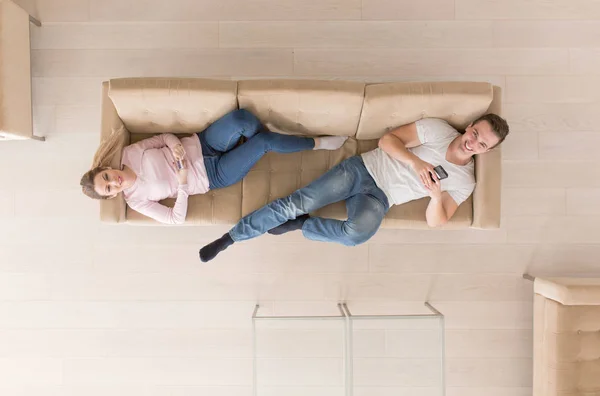 Jovem casal no sofá assistindo televisão vista superior — Fotografia de Stock