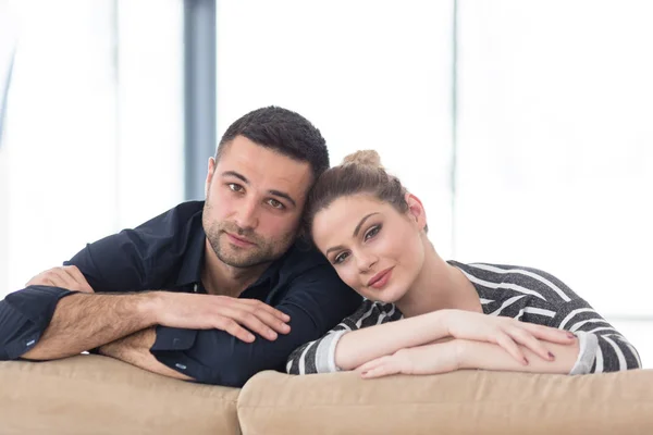 Retrato de jovem casal sentado no sofá — Fotografia de Stock