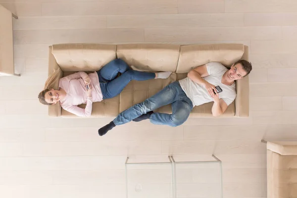 Jovem casal no sofá assistindo televisão vista superior — Fotografia de Stock