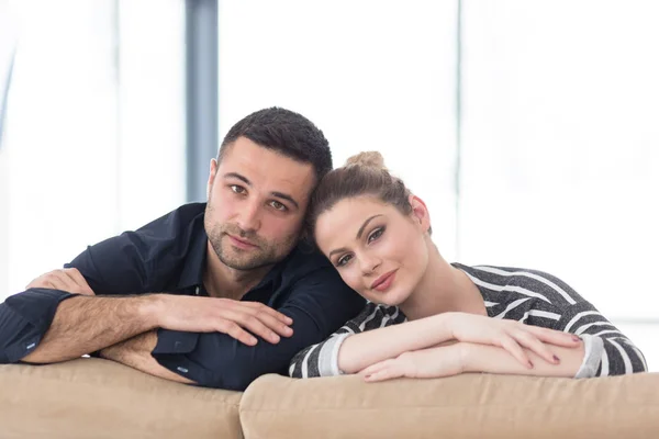 Retrato de pareja joven sentada en el sofá Imágenes de stock libres de derechos