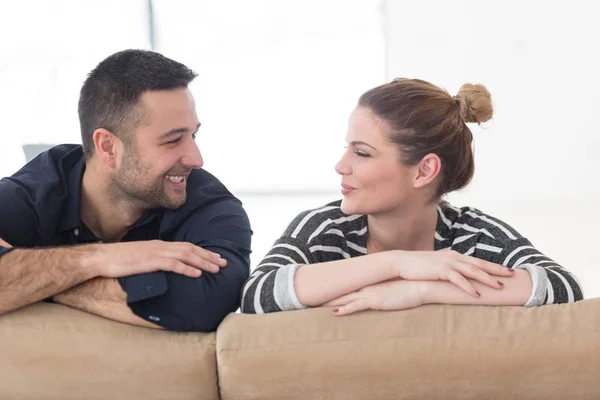 Portrait of young couple sitting on sofa — Stock Photo, Image