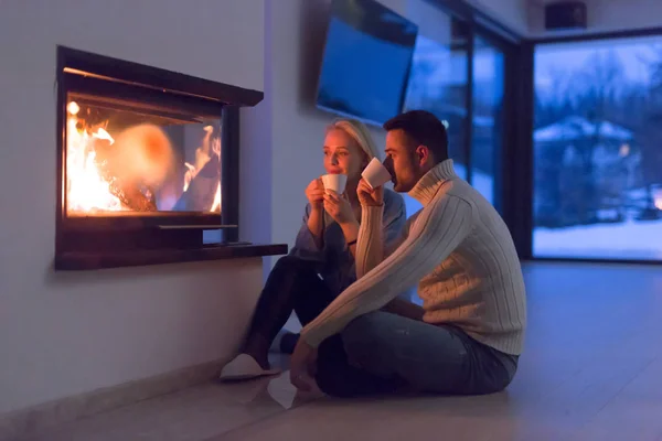 Happy couple in front of fireplace — Stock Photo, Image