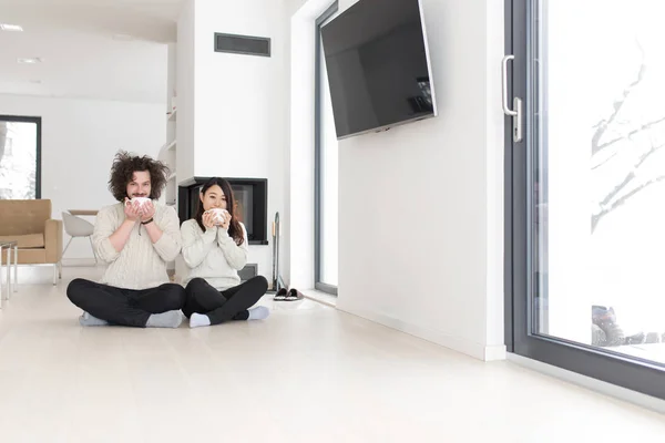 Feliz pareja multiétnica frente a la chimenea — Foto de Stock