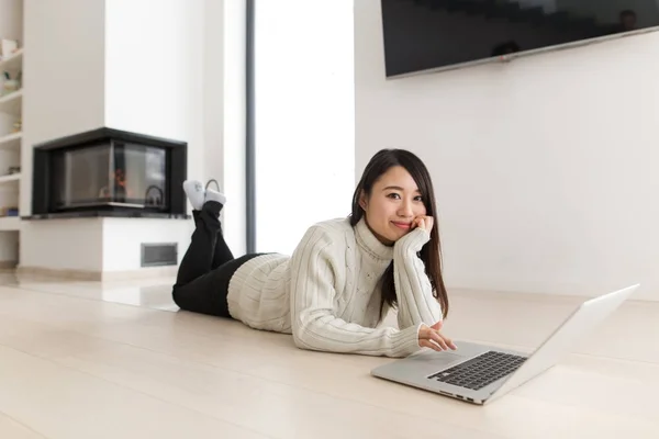 Jeune femme asiatique en utilisant un ordinateur portable sur le sol — Photo
