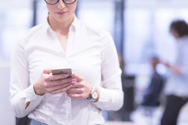 Mulher elegante usando telefone celular no prédio de escritórios de inicialização — Fotografia de Stock