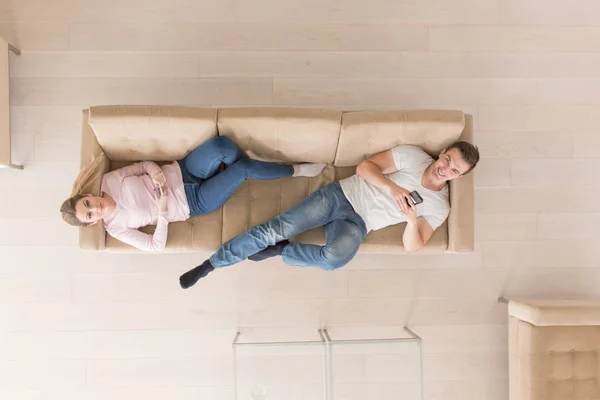 Pareja joven en el sofá viendo la televisión vista superior —  Fotos de Stock