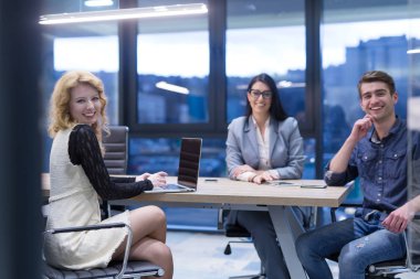 Bir grup genç iş adamı modern ofis binasında iş planlarını tartışıyor