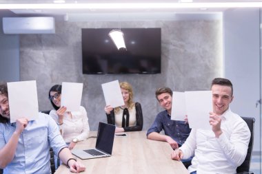 başlangıç iş ekibi beyaz bir kağıt yüz üzerinde tutarak