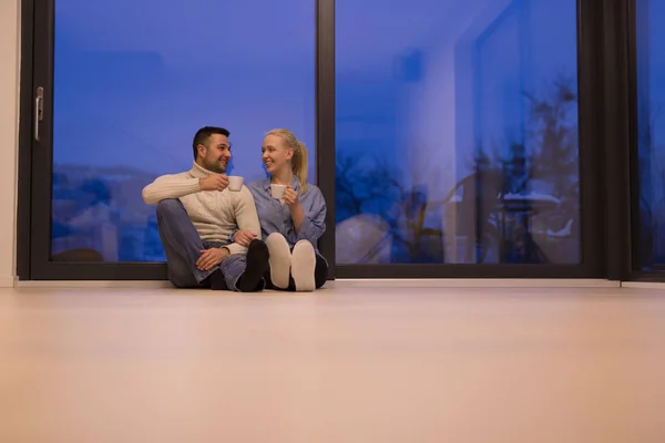 Casal sentado no chão na frente da lareira — Fotografia de Stock