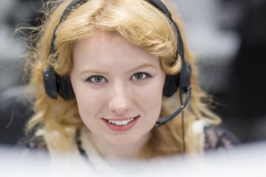 Gülümseyen kadın çağrı merkezi operatörü