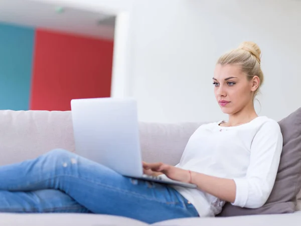 Mujer joven usando el ordenador portátil en casa — Foto de Stock