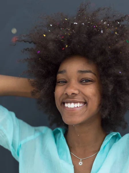 Černá žena fouká konfety ve vzduchu — Stock fotografie