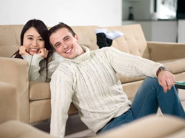 Lyckliga multietniskt par avkopplande hemma — Stockfoto