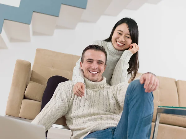 Feliz casal multiétnico relaxante em casa — Fotografia de Stock