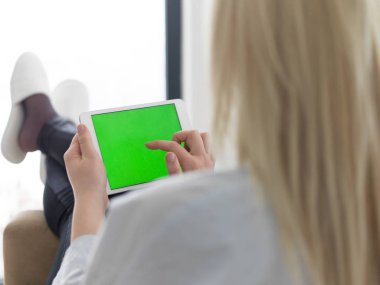 tablet bilgisayar şömine önünde kullanan genç kadın