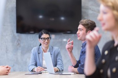 Bir grup genç iş adamı modern ofis binasında iş planlarını tartışıyor