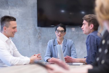 Bir grup genç iş adamı modern ofis binasında iş planlarını tartışıyor
