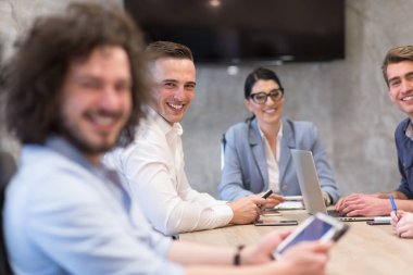 Bir grup genç iş adamı modern ofis binasında iş planlarını tartışıyor