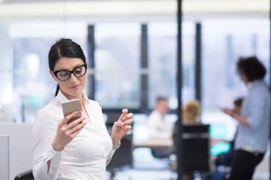 Zarif kadın kullanarak cep telefonu Başlangıç Ofis Binası